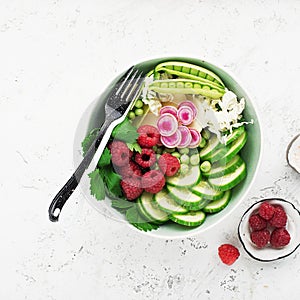 Vegetables summer fruit detox bowl. Vegetarian healthy food. Salads, lettuce leaves, raspberries, green peas, cucumber