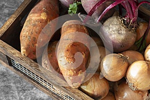 Vegetables, sweet potato onions and beetroot, in a wood and wire crate box.