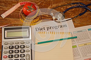 Vegetables, tomato. Measure tape, calculator, notepad and fresh tomato in the background. Healthy lifestyle diet