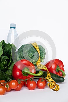 Vegetables and water with tape line on white background. Healthy food concept. Copy space.