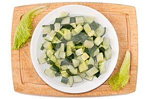 Vegetables on white background. Cucumbers, greens, cutting board, plate on a white background