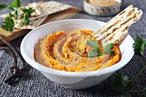 Vegetarian appetizer. Carrot dip on dry bread, sesame dressing and parsley