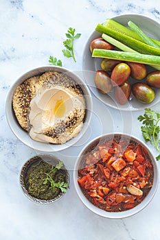 Vegetarian appetizers: hummus, roasted peppers salad, pesto and fresh vegetables