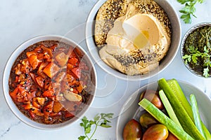 Vegetarian appetizers: hummus, roasted peppers salad, pesto and fresh vegetables