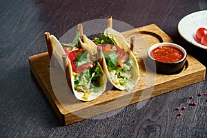 Vegetarian Appetizing Mexican tacos with tomatoes and bell pepper, cabbage, onions and parsley in special stands. Traditional