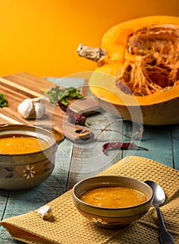 Vegetarian autumn pumpkin cream soup. Pumpkin soup with spices on a wooden table