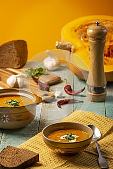 Vegetarian autumn pumpkin cream soup. Pumpkin soup with spices on a wooden table