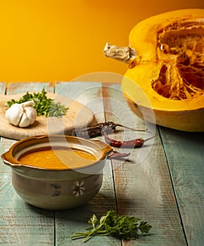 Vegetarian autumn pumpkin cream soup. Pumpkin soup with spices on a wooden table