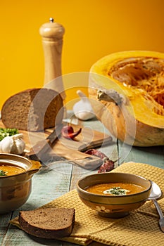 Vegetarian autumn pumpkin cream soup. Pumpkin soup with spices on a wooden table