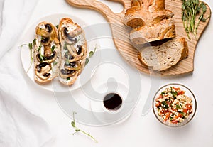 vegetarian breakfast without meat products. on a white table coffee, a salad of bulgur tabule, mushrooms sandwiche photo