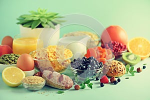 Vegetarian breakfast. Soft boiled egg, oat flakes, nuts, fruits, berries, milk, yogurt, orange, banana, peach on blue background.