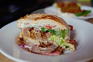 Vegetarian burger with seitan, tomato, lettuce, white bun with mayonnaise. Homemade veggie burger with seitan and sesame seeds