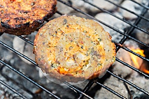 Vegetarian Burgers are cooking on grill with open flames