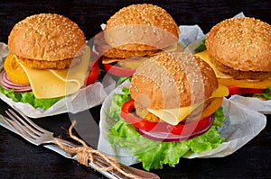 Vegetarian burgers with falafel, salad, onion, cheese and tomatoes on the black background. Traditional Middle Eastern fast food