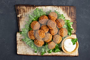 Vegetarian chickpeas falafel balls on wooden rustic board. Traditional Middle Eastern and arabian food.