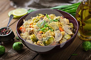 Vegetarian couscous salad with brussels sprouts, mushrooms, carrots and spices.