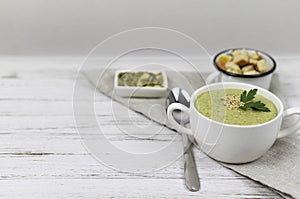 Vegetarian cream of broccoli, potato, onion, garlic, sesame and olive oil, and coconut milk .soup served in a white ceramic plate