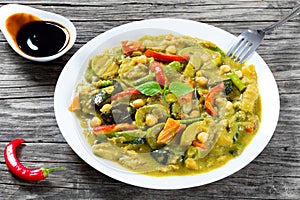 vegetarian curry with zucchini, eggplants, carrots, bell pepper, chickpeas, top-view