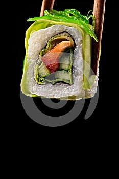 Vegetarian food concept. One sushi roll with papper, cucumber and cabbage, avocado