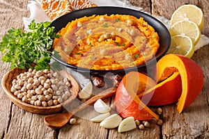 Vegetarian food: hummus with pumpkin and ingredients close-up. h