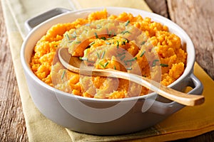 Vegetarian food: mashed sweet potatoes with herbs close-up on a