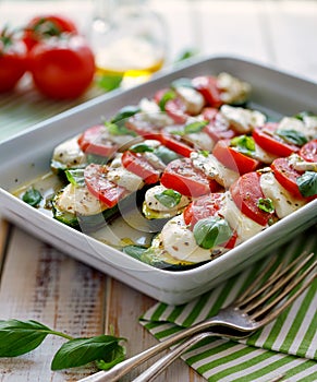 Vegetarian food, Zucchini with the addition of tomatoes, mozzarella, basil and olive oil caprese salad in a ceramic baking dish,