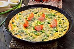 Vegetarian frittata with green onions and slices tomato