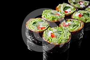 vegetarian futomaki sushi roll with cucumber, salmon, pepper, avocado salad on a black mirror background
