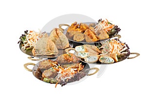 Vegetarian indian food or starters on metal plates including samosa on white background photo