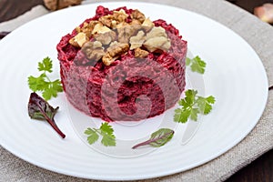 Vegetarian Lenten dish: a salad of beets with walnuts and garlic in a white plate