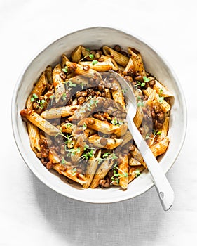Vegetarian lentil Bolognese sauce penne pasta on a light background, top view. Healthy eating concept