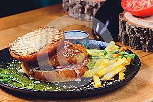 Vegetarian lentil burger in wholewheat bun with lettuce, tomato and cucumber accompanied by French fries Selective Focus