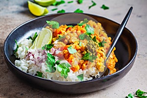 Vegetarian lentil curry with rice in black plate. Healthy vegan food concept