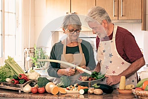 Vegetarian lifestyle. Beautiful white-haired senior couple in the kitchen prepare a vegetable soup. The man checks on her woman`s