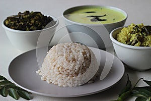 Vegetarian meals prepared in Kerala style. The serving includes boiled red rice, stir fried onions with grated coconut, stir fried