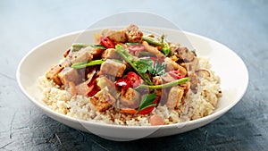 Vegetarian meat free mycoprotein pieces vegetable stir fry, brown rice served in white plate