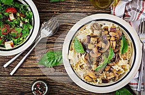 Vegetarian pasta with mushrooms and aubergines, eggplants and salad.