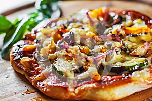 Vegetarian pizza with Mozzarella cheese, grilled zucchini, mushrooms, red onion, pepper and fresh basil. Italian pizza on wooden t