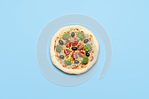 Vegetarian pizza uncooked on blue table. Raw vegan pizza, flat lay