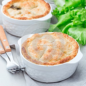 Vegetarian pot pie with lentil, mushroom, potato, carrot and green peas, covered with puff pastry, in a baking dish, square