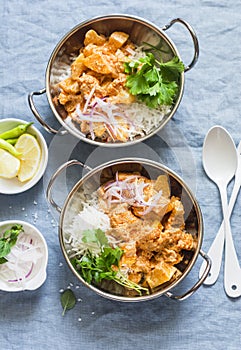 Vegetarian potato and cauliflower curry with rice in curry dishes on a blue background, top view. Vegetarian healthy food concept