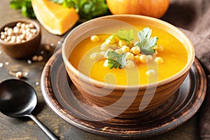 Vegetarian pumpkin and chickpea cream soup on a rustic wooden table. Comfort food, fall and winter healthy slow food concept