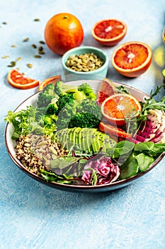 Vegetarian Quinoa bowl. Healthy breakfast or snack with detox quinoa with vegetables, avocado, blood orange, broccoli, watermelon
