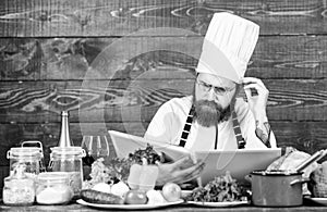 Vegetarian recipe. Man bearded hipster read book recipe near table fresh vegetables. Culinary arts. Recipe to cook