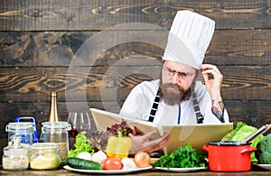 Vegetarian recipe. Man bearded hipster read book recipe near table fresh vegetables. Culinary arts. Recipe to cook