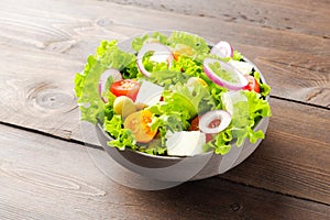 Vegetarian salad on wooden background with feta cheese