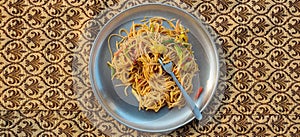 Vegetarian Schezwan Noodles or Vegetable Hakka Noodles or Chow Mein in black bowl at dark background.