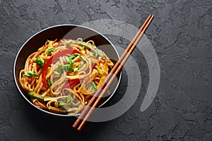 Vegetarian Schezwan Noodles or Vegetable Hakka Noodles or Chow Mein in black bowl at dark background. Indo-chinese cuisine hot