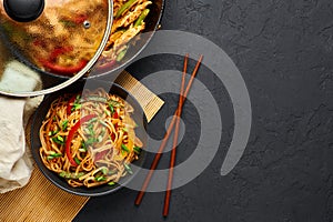 Vegetarian Schezwan Noodles or Vegetable Hakka Noodles or Chow Mein in black bowl at dark background. Indo-chinese cuisine hot