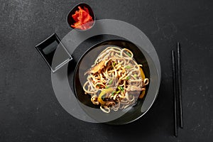 Vegetarian Schezwan Noodles or Vegetable Hakka Noodles or Chow Mein in black bowl at dark background. Schezwan Noodles